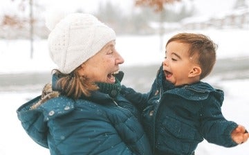 Grandmother playing with her grandson in the snow