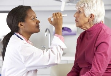 Opthamologist examining an elder woman's eyes